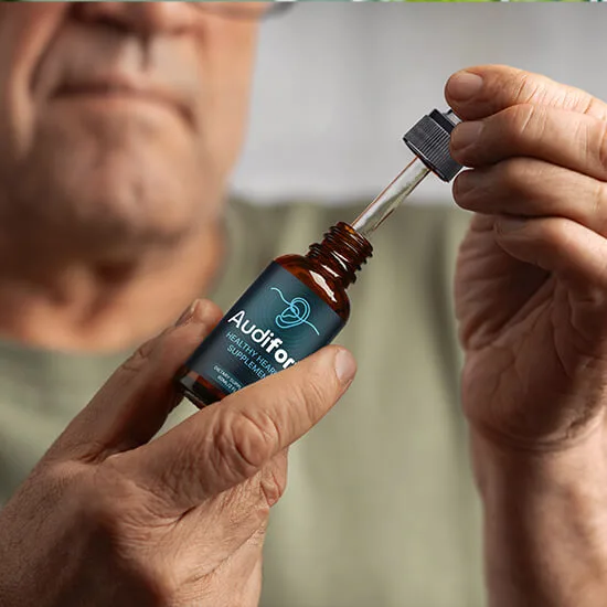 A person holding an Audifort liquid supplement bottle and dropper